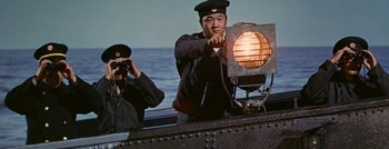 Movie still from “Hell and High Water” (1954), directed by Samuel Fuller – A man on a boat in the water with a camera; Medium shot, Low angle