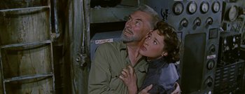 Movie still from “Hell and High Water” (1954), directed by Samuel Fuller – An older man and a young woman are looking at each other; Medium shot, High angle