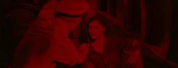 Movie still from “Hell and High Water” (1954), directed by Samuel Fuller – An old man and a young man in a dark room; Close Up shot, Overhead angle