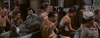 Movie still from “Hell and High Water” (1954), directed by Samuel Fuller – A group of men sitting on top of a bench; Medium shot, High angle