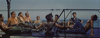 Movie still from “Hell and High Water” (1954), directed by Samuel Fuller – A group of men sitting in a row boat on a body of water; Wide shot, Overhead angle