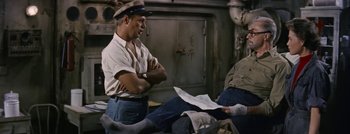 Movie still from “Hell and High Water” (1954), directed by Samuel Fuller – A man standing next to another man on a boat; Medium shot, High angle