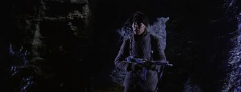 Movie still from “Hell and High Water” (1954), directed by Samuel Fuller – A man holding a rifle in a dark cave; Medium shot, Low angle