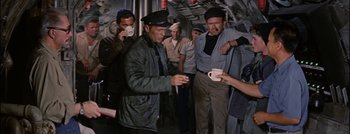 Movie still from “Hell and High Water” (1954), directed by Samuel Fuller – A group of men standing next to each other on a boat; Medium shot, High angle