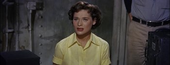 Movie still from “Hell and High Water” (1954), directed by Samuel Fuller – A woman in a yellow shirt is looking at the camera; Close Up shot, High angle