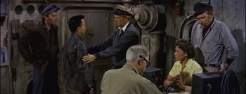 Movie still from “Hell and High Water” (1954), directed by Samuel Fuller – A group of people standing around a building; Medium shot, Over the shoulder angle