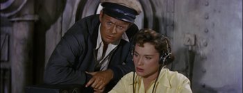 Movie still from “Hell and High Water” (1954), directed by Samuel Fuller – A man and a woman are listening to music; Close Up shot, Overhead angle