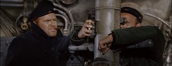 Movie still from “Hell and High Water” (1954), directed by Samuel Fuller – Two men working together on a metal structure; Medium shot, Overhead angle