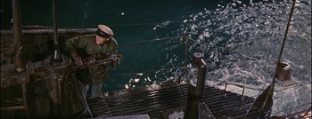 Movie still from “Hell and High Water” (1954), directed by Samuel Fuller – A man standing on a boat in the water; Wide shot, Overhead angle