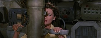 Movie still from “Hell and High Water” (1954), directed by Samuel Fuller – A woman looking through a hole in a wall; Close Up shot, High angle