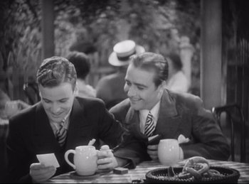 Movie still from “Hell's Angels” (1930), directed by Edmund Goulding – Two young men sitting at a table drinking coffee; Medium shot, High angle