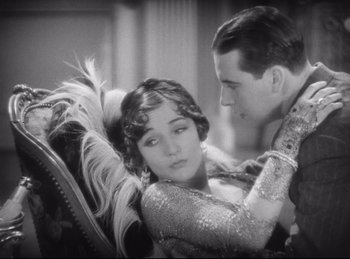 Movie still from “Hell's Angels” (1930), directed by Edmund Goulding – A man and a woman sitting on a couch; Medium shot, High angle