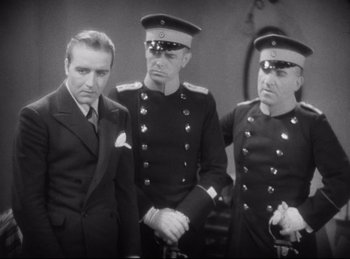 Movie still from “Hell's Angels” (1930), directed by Edmund Goulding – A group of three men standing next to each other; Medium shot, Low angle