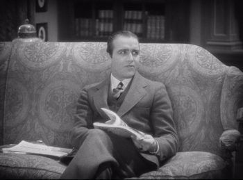 Movie still from “Hell's Angels” (1930), directed by Edmund Goulding – A black and white photo of a man sitting on a couch; Medium shot, High angle