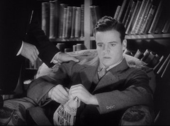Movie still from “Hell's Angels” (1930), directed by Edmund Goulding – A man in a suit and tie holding a bag; Medium shot, Low angle