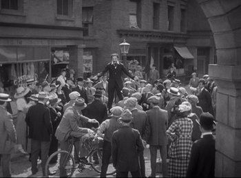 Movie still from “Hell's Angels” (1930), directed by Edmund Goulding – An old photo of a crowd of people on the street; Extreme Wide shot, High angle