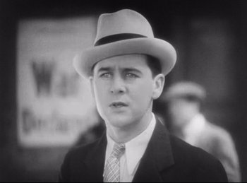 Movie still from “Hell's Angels” (1930), directed by Edmund Goulding – A man in a suit and a hat; Close Up shot, Low angle