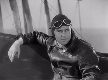 Movie still from “Hell's Angels” (1930), directed by Edmund Goulding – A man wearing a leather jacket and goggles; Medium shot, Low angle