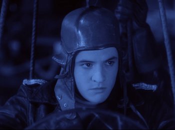 Movie still from “Hell's Angels” (1930), directed by Edmund Goulding – A young man wearing a helmet in a dark room; Close Up shot, Low angle