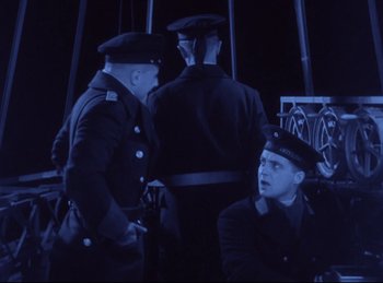 Movie still from “Hell's Angels” (1930), directed by Edmund Goulding – A group of men standing next to each other on a field; Medium shot, High angle