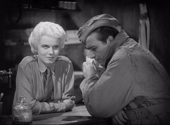Movie still from “Hell's Angels” (1930), directed by Edmund Goulding – An old photo of a man and a woman sitting at a table; Medium shot, Over the shoulder angle
