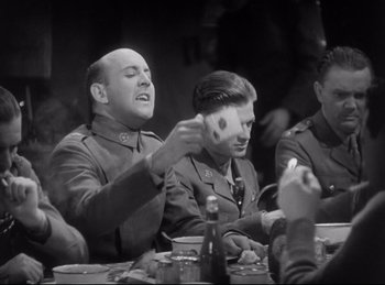 Movie still from “Hell's Angels” (1930), directed by Edmund Goulding – A group of men sitting at a table playing cards; Medium shot, Over the shoulder angle