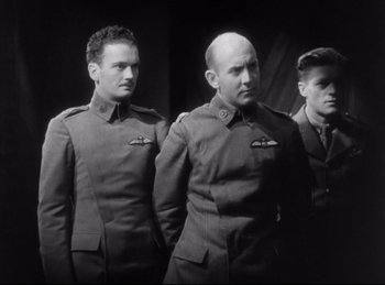 Movie still from “Hell's Angels” (1930), directed by Edmund Goulding – A black and white photo of three men in uniforms; Medium shot, Low angle