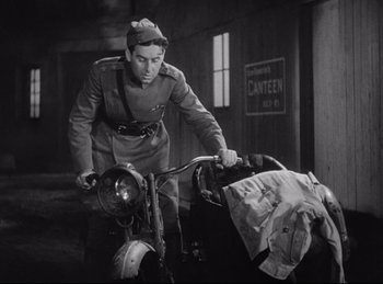 Movie still from “Hell's Angels” (1930), directed by Edmund Goulding – An old photo of a man on a motorcycle; Medium shot, High angle