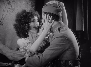 Movie still from “Hell's Angels” (1930), directed by Edmund Goulding – An old photo of a woman and a soldier; Medium shot, High angle