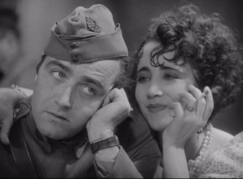 Movie still from “Hell's Angels” (1930), directed by Edmund Goulding – A man and a woman posing for a picture; Close Up shot, Low angle