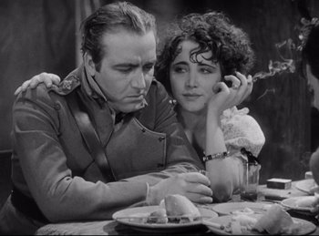 Movie still from “Hell's Angels” (1930), directed by Edmund Goulding – A man and a woman sitting next to each other at a table; Close Up shot, High angle