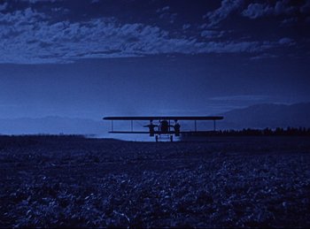 Movie still from “Hell's Angels” (1930), directed by Edmund Goulding – An airplane is sitting in the middle of a field; Extreme Wide shot, Low angle