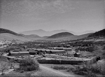 Movie still from “Hell's Angels” (1930), directed by Edmund Goulding – A black and white photo of a town with mountains in the background; Extreme Wide shot, High angle