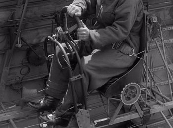 Movie still from “Hell's Angels” (1930), directed by Edmund Goulding – A man sitting in an old fashioned airplane; Medium shot, High angle