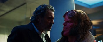 Movie still from “Hellboy” (2019), directed by Neil Marshall – A man in a suit stares at another man in a red mask; Close Up shot, Over the shoulder angle