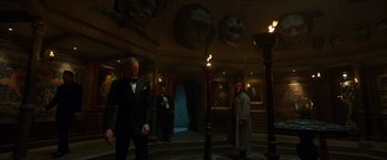 Movie still from “Hellboy” (2019), directed by Neil Marshall – A man in a suit and tie standing in front of a wall; Wide shot, Low angle