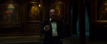 Movie still from “Hellboy” (2019), directed by Neil Marshall – A man in a tuxedo holding a glass of wine; Medium shot, Low angle