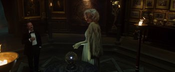 Movie still from “Hellboy” (2019), directed by Neil Marshall – A woman in a white dress standing next to a crystal ball; Medium shot, High angle
