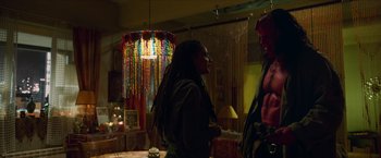 Movie still from “Hellboy” (2019), directed by Neil Marshall – A man and a woman standing in a living room; Medium shot, Over the shoulder angle
