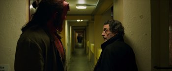 Movie still from “Hellboy” (2019), directed by Neil Marshall – A man and a demon in a hallway of a building; Medium shot, Over the shoulder angle