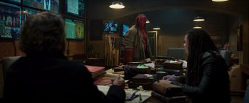 Movie still from “Hellboy” (2019), directed by Neil Marshall – A man with a red mask standing in front of a table; Wide shot, Over the shoulder angle