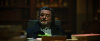 Movie still from “Hellboy” (2019), directed by Neil Marshall – A person sitting at a table; Close Up shot, Low angle