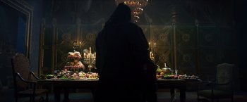 Movie still from “Hellboy” (2019), directed by Neil Marshall – A woman standing in front of a table filled with plates of food; Wide shot, High angle