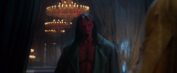 Movie still from “Hellboy” (2019), directed by Neil Marshall – A man with a red face is standing in front of a chandelier; Wide shot, Over the shoulder angle