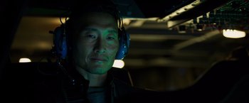 Movie still from “Hellboy” (2019), directed by Neil Marshall – A man wearing ear muffs in a dark room; Close Up shot, Over the shoulder angle