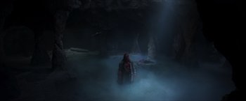 Movie still from “Hellboy” (2019), directed by Neil Marshall – A person in a cave with fog coming out of the cave; Wide shot, High angle