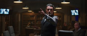 Movie still from “Hellboy” (2019), directed by Neil Marshall – A man in a black vest is pointing his finger at the camera; Medium shot, Low angle