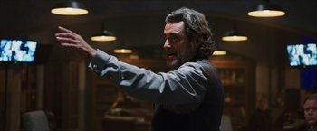 Movie still from “Hellboy” (2019), directed by Neil Marshall – A man with long hair and a goatee is pointing; Medium shot, Over the shoulder angle