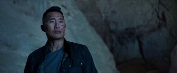 Movie still from “Hellboy” (2019), directed by Neil Marshall – A man in a dark cave with blood on his face; Close Up shot, Over the shoulder angle