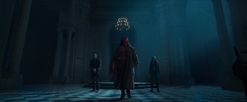 Movie still from “Hellboy” (2019), directed by Neil Marshall – A group of people standing in a room; Wide shot, Low angle